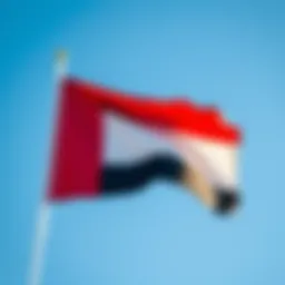 The UAE national flag waving proudly against a clear blue sky